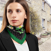 Woman wearing a colourful scarf with a building and tree in the background- Eyam in the Peaks